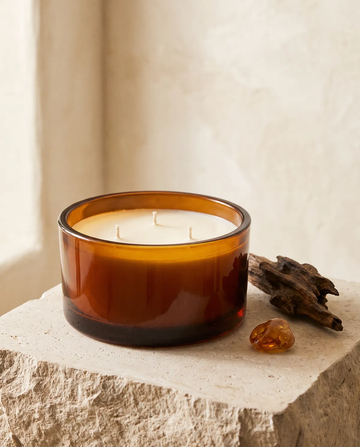 Amber & Oud three-wick candle in an amber glass bowl